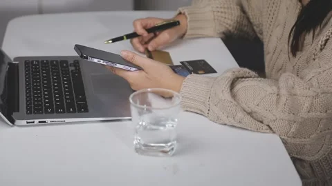 Girl makes a purchase on the Internet on the computer with credit card Stock Footage 313583963