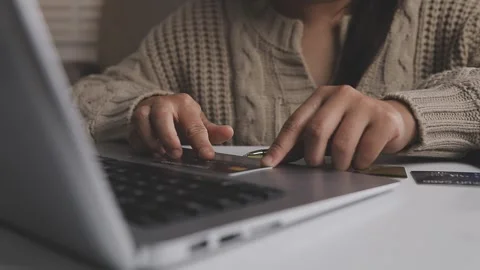 Girl makes a purchase on the Internet on the computer with credit card Stock Footage 313584258