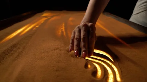 Girl makes sand patterns on the table, sand animation Stock Footage 98498011
