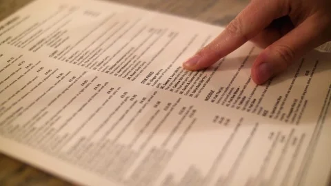 Girl makes selection from a Thai menu 스톡 동영상 82793317