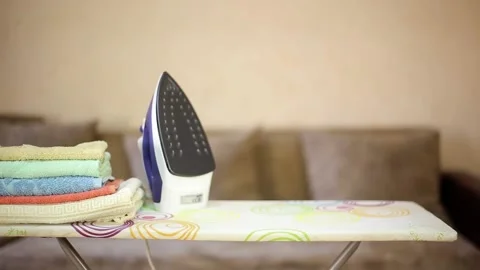 The girl makes stuff and puts it on the Ironing Board near the iron Stock Footage 138418320
