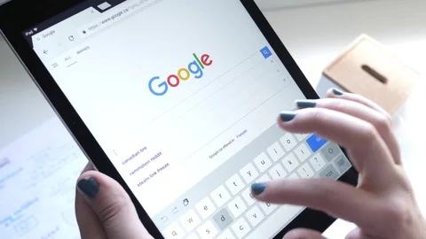 Girl Making a Google Search on Her Tablet Device Stockbeeldmateriaal 80601236