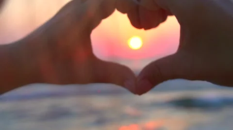 Royalty-Free photo: Couple's hands forming heart gesture