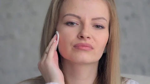 Girl Making her face clean and fresh. Beautiful young woman wiping her face with 스톡 동영상 72866053