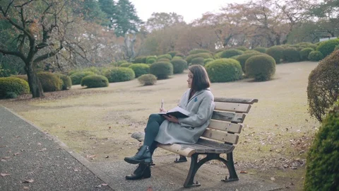 Girl making notes in park 3 Stock Footage 99207622