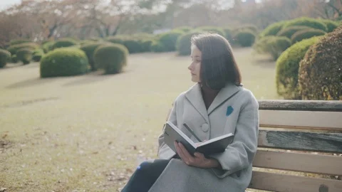 Girl making notes in the park 4 Stock Footage 99207582