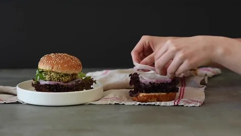 Girl making veggie burger on table Stock Footage 74015563