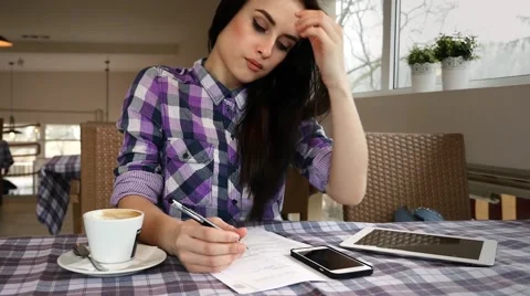 Girl makng notes while sitting in the restaurant. Tablet pc and mobile phone. Stock Footage 61408823