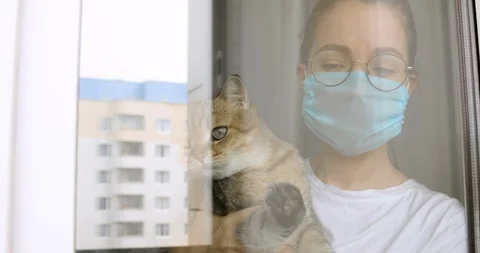 Girl in mask with cat is missing about usual normal life on quarantine at home. Stock Footage 129309568