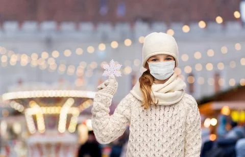 Girl in mask with snowflake over christmas market Stock Photos