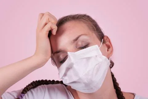 Girl in a medical mask. Girl on a pink background. Stock Photos