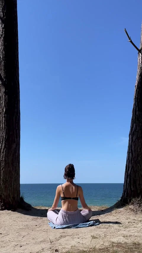 Girl meditating on beach Stockbeeldmateriaal 279398024