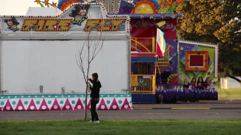 Girl messing with tree at fair Stock Footage 154941156