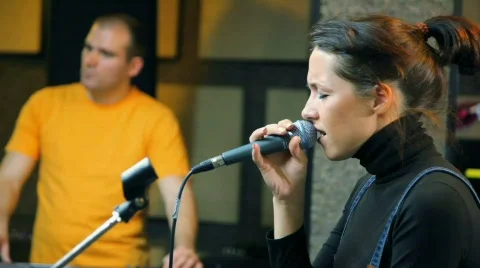 Girl with microphone singing in studio Stock Footage