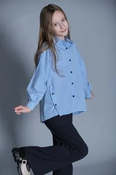 Girl in mid-pose with a charming smile, wearing a fresh blue shirt. Suits Stock Photos
