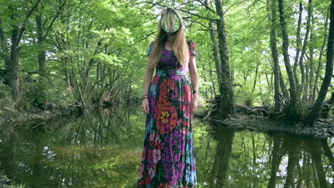 Girl with a mirror instead of a face in the middle of pristine nature Stock Footage 130349772