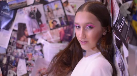  Girl Model Brunette playing with her Hair - close-up against magazine clippings Stock Footage 59192773
