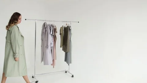 Girl model posing in an unbuttoned raincoat and spinning next to the hanger Stock Footage 108178209