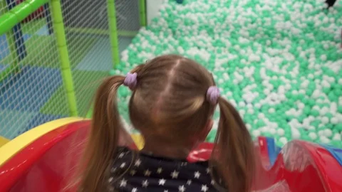 Girl moving down slide on playground in children's center Video stock 101893603