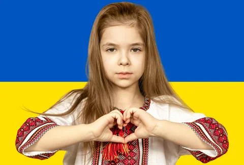 A girl in national Ukrainian clothes, an embroidered shirt, shows a heart sign Stock Photos