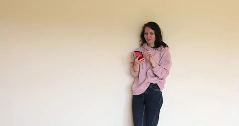 Girl near the wall talking fun on the phone Stock Footage