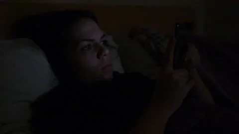 Girl at night watching videos on your phone Stock Footage