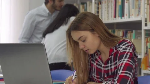 Girl notes from the laptop at the library Stock-Footage 74285726