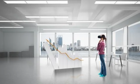 Girl in office interior in virtual reality mask using innovative technologies Stock Photos