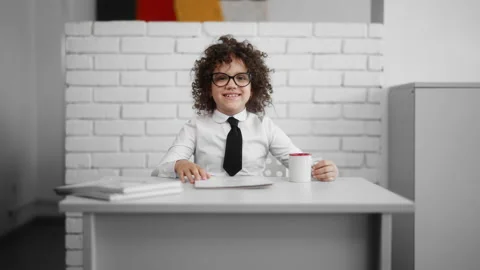Girl in office sitting at the wooden desk, reading documents and smiling Stock Footage