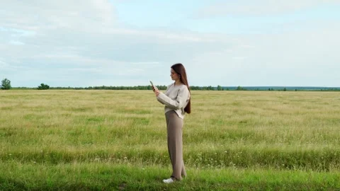 A girl in an open field cannot catch a cellular signal. Stock Footage 281672068