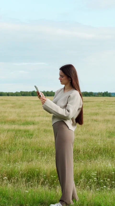 A girl in an open field cannot catch a cellular signal. Stock Footage 282086129