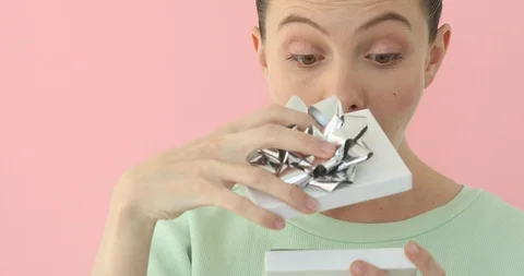 Girl opening present isolated on pink background Stock Footage 89317853