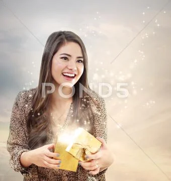 Girl opening a shinning giftbox Stock Photos