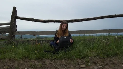 The girl opens the bag and pulls out the camera, looks at the photos Stock Footage 126915245