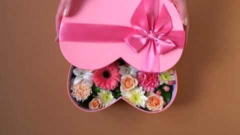 Girl opens box with a gift in the shape of heart with a bow Stock Footage 170756114