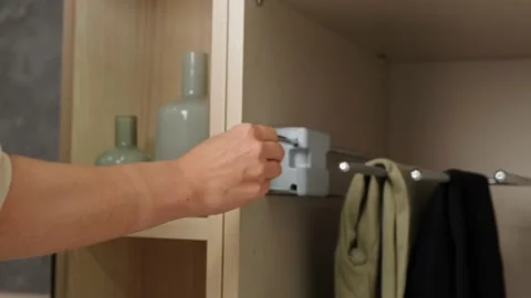 The girl opens the closet and pulls out the pants support system 库存影片 178893458