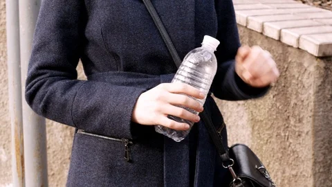 The girl opens an empty plastic bottle. Concept close-up. Stock Footage 105464874