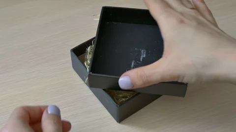 Girl opens a gift for Valentine's Day note wrapped with string "love you" Stock Footage 106956502