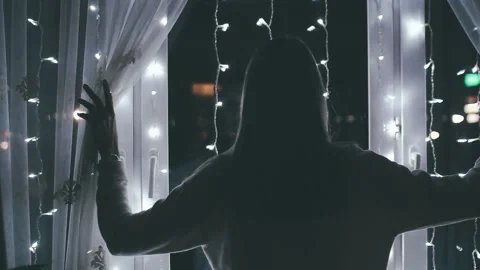 Girl opens the light curtains on the window with a garland Stock Footage 88234481