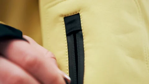 The girl opens the locks on the yellow jacket. Close up Stock Footage 144693895