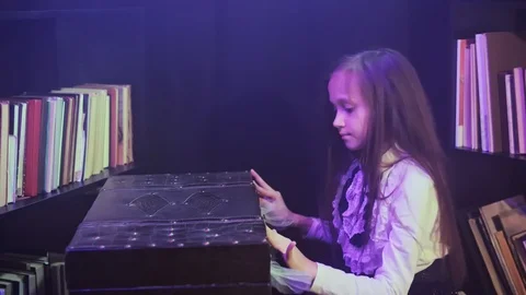 Girl opens a magic chest from which light and colored smoke burst Stock Footage 120091745