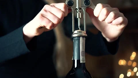 The girl opens the wine with a corkscrew Stock Footage 151797345