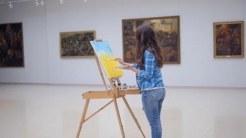 Girl painting on canvas in picture gallery. Stock Footage