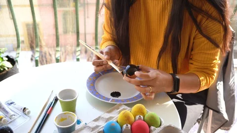 A girl paints an Easter egg with a brush in black, in view of the approaching Video stock 127850227