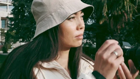 A girl in the park is looking for an object to shoot and takes it to the camera Stock Footage 221576298