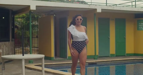 A girl in a patterned retro bikini at a stylish 60s-inspired hotel. Video stock 332064222