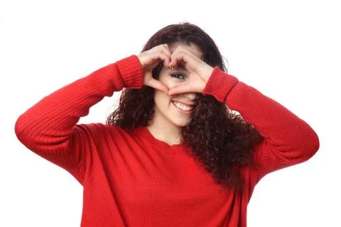 Girl peeking through heart shape hand sign Stock Photos
