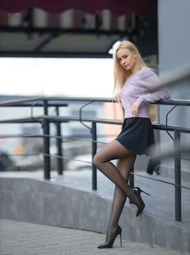 Girl with perfect legs in pantyhose at the city square. Stock Photos