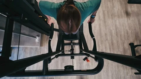 Girl Performs Assisted Dips On Parallel Bars In Gym, Legs Supported Stock Footage 322803612
