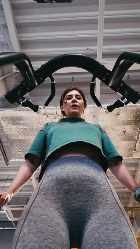 Girl Performs Assisted Dips On Parallel Bars In Gym, Legs Supported Stock-Footage 329133416